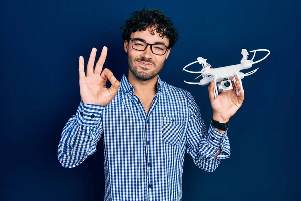 İspanyol asıllı genç bir adam İHA 'yı tutuyor. Parmaklarıyla imza atıyor, gülümsüyor. 