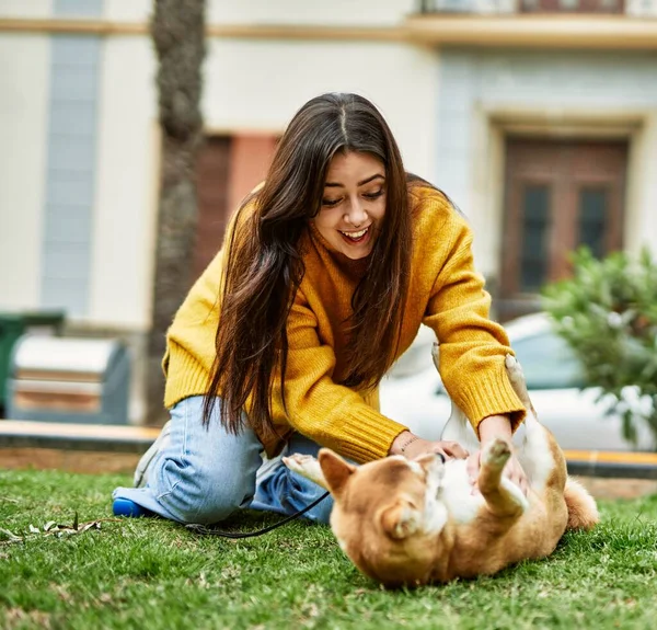 公園で幸せな柴犬を抱きしめる美しい若い女性 — ストック写真