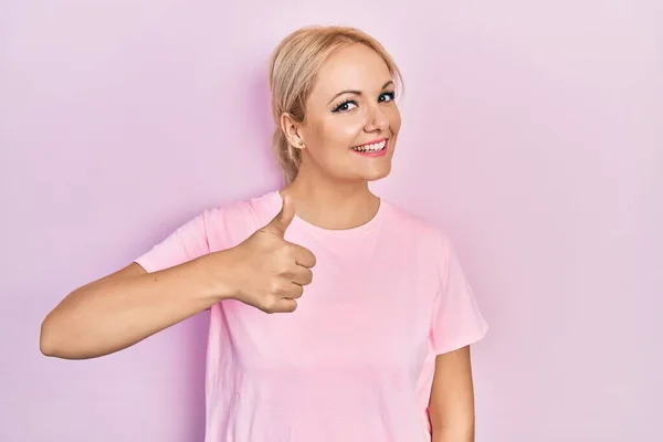 Jonge Blonde Vrouw Draagt Casual Roze Shirt Doet Vrolijke Duimen — Stockfoto