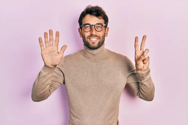 Przystojny Mężczyzna Brodą Swetrze Golfem Okularami Pokazujący Wskazujący Palcami Numer — Zdjęcie stockowe