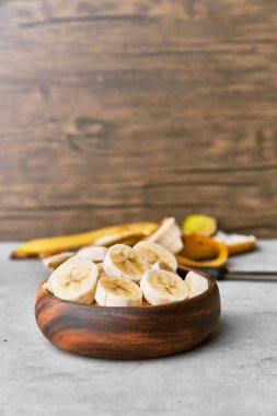 Beton bir yüzey üzerinde bir kasede muz dilimleri fotoğrafı