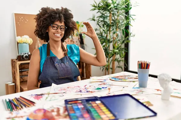 美丽动人的非洲裔美国女人 在艺术工作室里画着非洲裔的头发 面带微笑 自信地做手势 手拿着小尺寸的标志 手拿着手指和相机 计量概念 — 图库照片