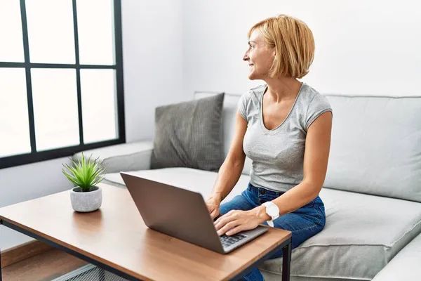 Blonde Frau Mittleren Alters Mit Laptop Hause Zur Seite Schauen — Stockfoto