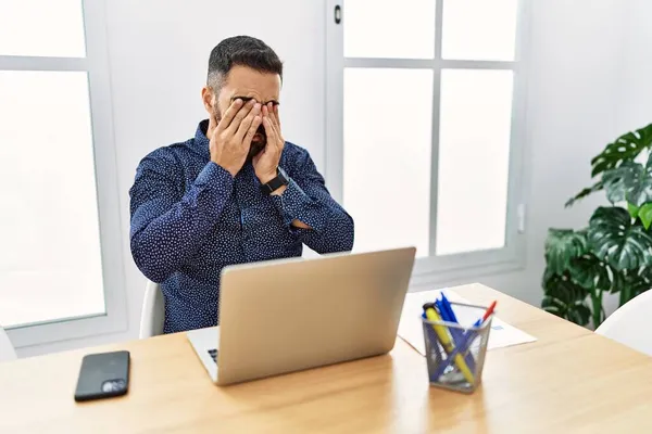 Jovem Hispânico Com Barba Trabalhando Escritório Com Laptop Esfregando Olhos — Fotografia de Stock