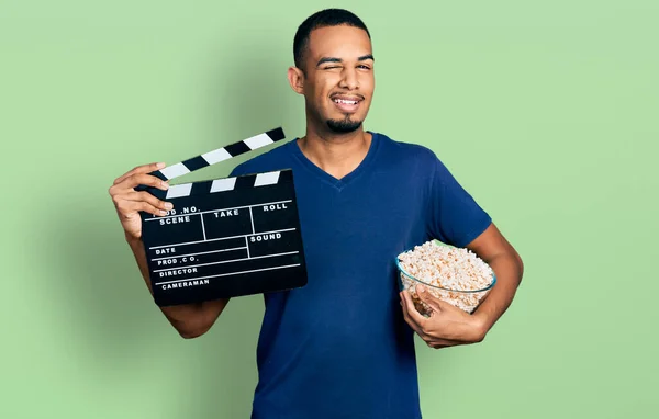 Mladý Africký Američan Jíst Popcorn Drží Film Clapboard Mrkání Kameru — Stock fotografie
