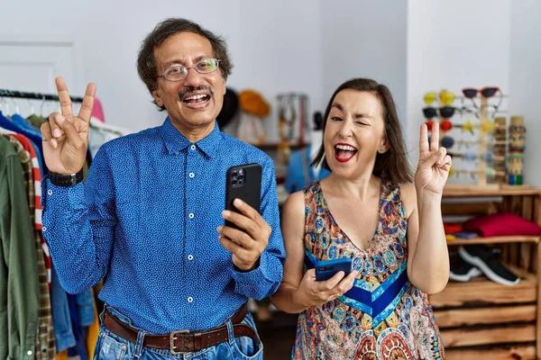 Middle Age Interracial Couple Retail Shop Using Smartphone Smiling Happy — Stock Photo, Image