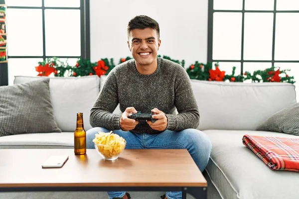 Young Hispanic Man Palying Video Game Sitting Sofa Christmas Decor — Stok fotoğraf