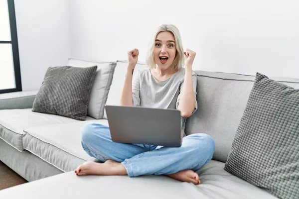 Young Caucasian Woman Using Laptop Home Sitting Sofa Celebrating Surprised — Stok fotoğraf