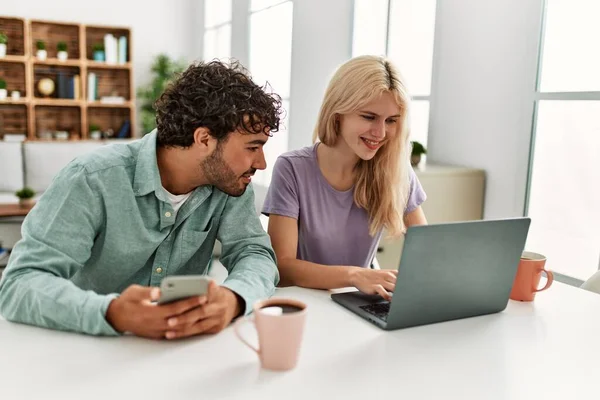 Unga Par Använder Laptop Och Smartphone Dricka Kaffe Hemma — Stockfoto