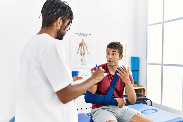 Zwei Männer Physiotherapeut Und Patient Reha Schreiben Unfallbericht Klinik — Stockfoto