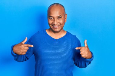 Orta yaşlı, gündelik kıyafetler giyen, kendine güvenen, gülümseyen, kendini gururlu ve mutlu gösteren bir adam.. 