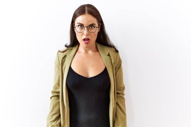 Young brunette woman standing over isolated background afraid and shocked with surprise and amazed expression, fear and excited face. 