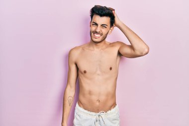 Mayo giyen genç İspanyol bir adam tişörtsüz bir kafa karışıklığı ve soru sormayı merak ediyor. Şüpheyle kararsız, kafa kafaya düşünerek. Düşünceli kavram. 