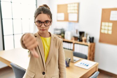 Genç esmer genç, ofiste iş elbisesi giymiş mutsuz ve kızgın görünüyor. Reddedilmiş ve olumsuz hareketler yapıyor. kötü ifade. 