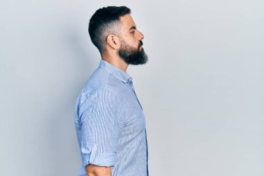 Latin kökenli genç adam rahat bir görünüm takınıyor, rahat bir görünüm takınıyor, kendine güvenen bir gülümsemeyle.. 