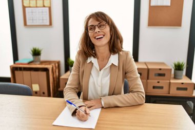 Kafkasyalı genç işkadını ofiste çalışan evrak işleriyle uğraşıyor..