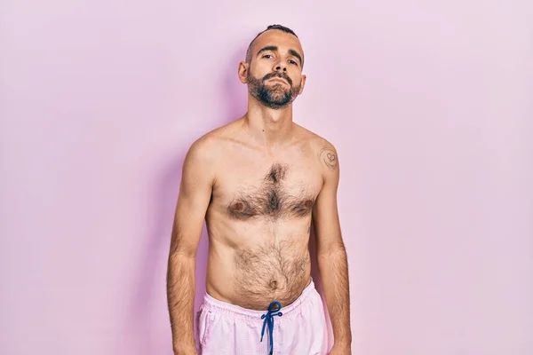 Young Hispanic Man Shirtless Wearing Swimsuit Relaxed Serious Expression Face — Foto de Stock