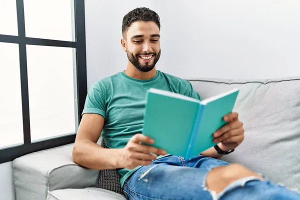 Jovem Árabe Homem Lendo Livro Deitado Sofá Casa — Fotografia de Stock