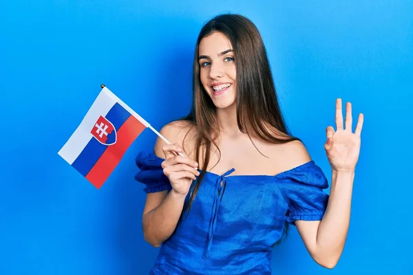 Young Brunette Teenager Holding Slovakia Flag Doing Sign Fingers Smiling — Stockfoto