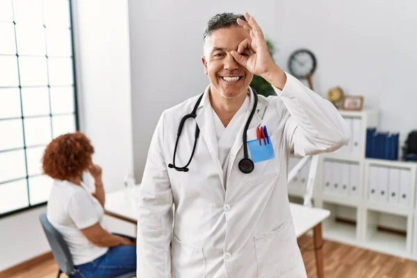Lekarz Średnim Wieku Klinice Pacjentem Robi Gest Uśmiechem Dłoni Oko — Zdjęcie stockowe
