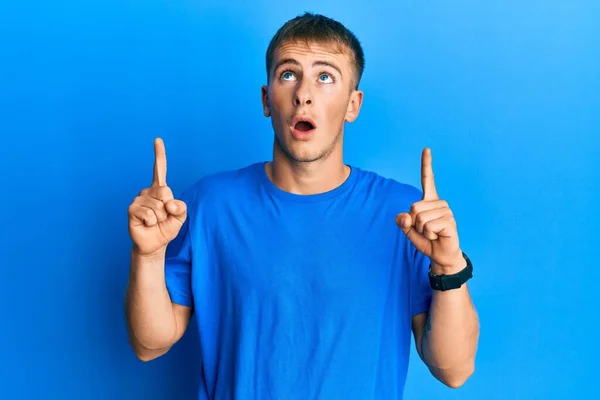 Young Caucasian Man Wearing Casual Blue Shirt Amazed Surprised Looking — Stockfoto