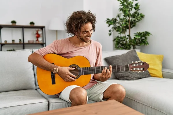 Jovem Hispânico Sorrindo Feliz Tocando Guitarra Clássica Sentado Sofá Casa — Fotografia de Stock