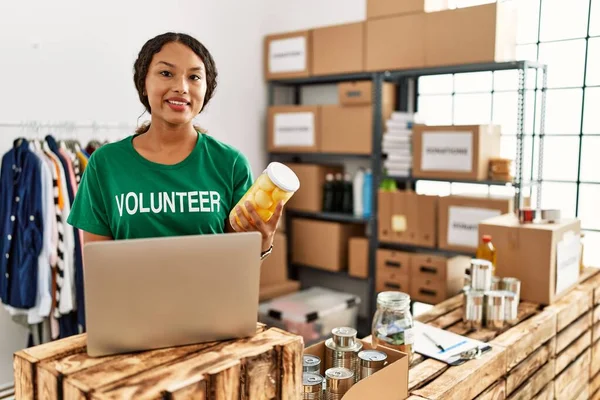 Ung Latinamerikansk Kvinna Bär Volontär Uniform Med Bärbar Dator Välgörenhetscenter — Stockfoto