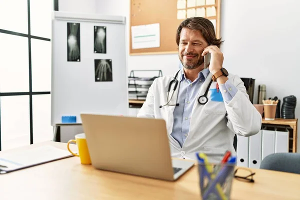 Hombre Caucásico Mediana Edad Vistiendo Uniforme Médico Hablando Teléfono Inteligente —  Fotos de Stock