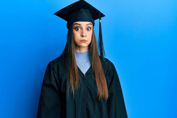 Beautiful Brunette Young Woman Wearing Graduation Cap Ceremony Robe Puffing — Stockfoto