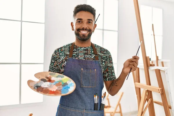 年轻的非洲艺术家在艺术工作室拿着画笔和调色板开心地笑着 — 图库照片