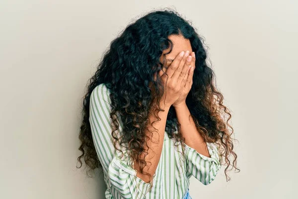 年轻的拉丁女人穿着休闲装 脸上挂着忧郁的表情 一边哭一边用手捂住脸 抑郁症的概念 — 图库照片