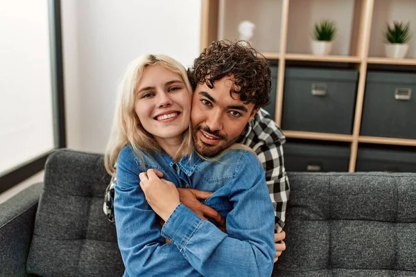 Jovem Casal Sentado Sofá Abraçando Casa — Fotografia de Stock