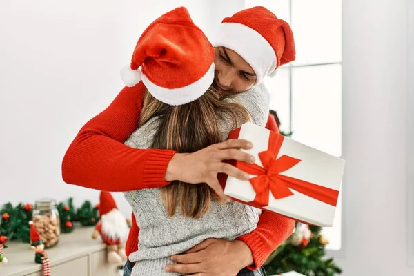 Pareja Joven Abrazándose Sonriendo Feliz Uso Sombrero Navidad Celebración Regalo —  Fotos de Stock