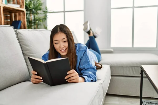 Mladý Číňan Dívka Čtení Kniha Ležící Pohovce Doma — Stock fotografie