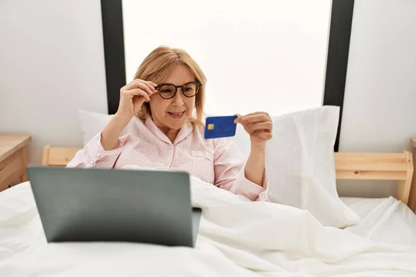 Medelålders Blond Kvinna Köper Med Laptop Och Kreditkort Ligger Sängen — Stockfoto