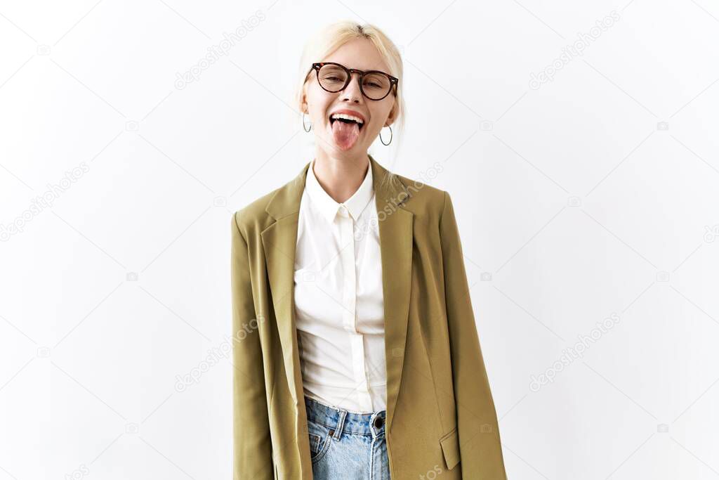 Beautiful caucasian business woman standing over isolated background sticking tongue out happy with funny expression. emotion concept. 