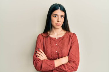 Günlük kıyafetler giyen genç İspanyol kadın yüzünde ciddi bir ifadeyle rahatlamış. Basit ve doğal bir şekilde kameraya bakıyorsun.. 