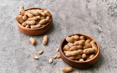 Beton bir yüzeyde kasede bir avuç fıstık.