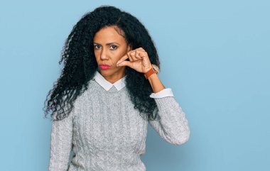 Orta yaşlı Afro-Amerikalı kadın sıradan kıyafetler giyiyor ağzı ve dudakları parmaklarıyla kapalı. gizli ve sessiz, tabu konuşması 