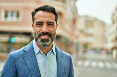 Orta yaşlı işadamı şehirde mutlu mesut dikilirken.