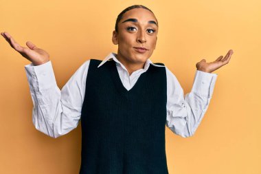 Makyaj yapan, uzun saçlı, modaya uygun kıyafetler giyen, kolları açık, hiçbir fikri olmayan, şüpheli bir yüzü olan İspanyol bir adam.. 