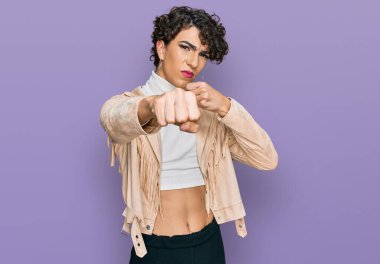 Handsome man wearing make up and woman clothes punching fist to fight, aggressive and angry attack, threat and violence 