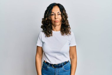 Orta yaşlı İspanyol kadın, günlük beyaz tişört giyiyor. Depresyonda ve üzüntüden ağlıyor, ağlıyor ve korkuyor. hüzünlü ifade. 