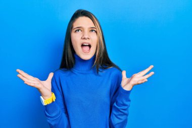 Balıkçı yaka kazak giyen genç esmer kız başarıyı deli gibi kutluyor. Kolları havada, gözleri kapalı heyecanla bağırıyor. Kazanan konsept 