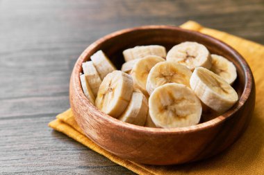 Tahta bir masada muz dilimlerinin fotoğrafı.