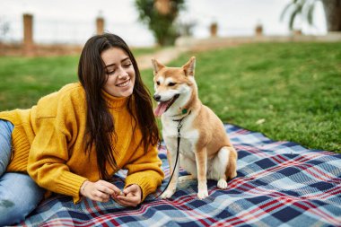 Parkta Shiba Inu köpeği olan güzel genç bir kadın.