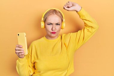 Kulaklık takan, kuşkucu ve gergin genç sarışın bir kadın sorun yüzünden kaşlarını çatıyor. negatif kişi. 