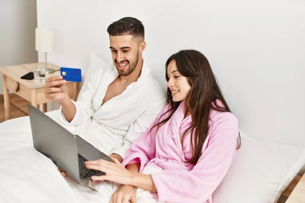Молода Іспаномовна Пара Використовує Ноутбук Картку Кредитита Лежить Ліжку Вдома — стокове фото