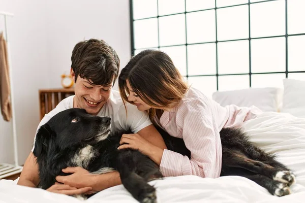 Unga Kaukasiska Par Ler Glada Liggande Sängen Leker Med Hunden — Stockfoto