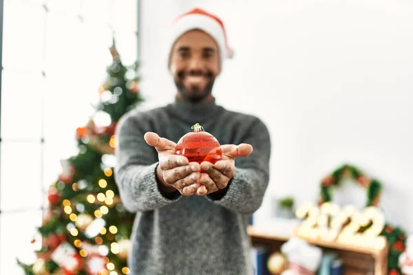 Young African American Man Smiling Happy Holding Christmas Ball Home — Stock Photo, Image